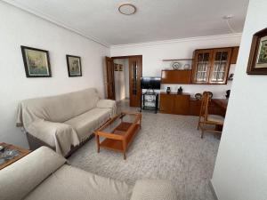 a living room with a couch and a table at Apartamentos La Laguna II in Los Alcázares +33 photos