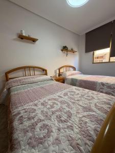 a bedroom with two beds and a window at Apartamentos La Laguna II in Los Alcázares