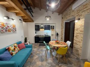 a living room with a blue couch and a table at Hermès Home in Agrigento