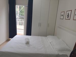 a white bed in a room with a window at Cantinho da Paz in Sao Paulo