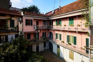 an apartment building with balconies and a courtyard at Cozy Studio a few Steps from Sesto Rondò Metro Station in Sesto San Giovanni