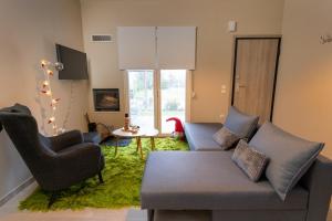 a living room with a couch and chairs and a table at Το σπίτι στο χωριό in Tríkala