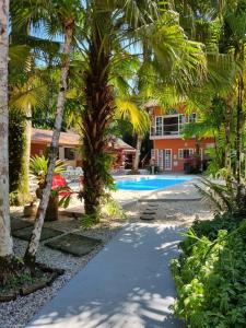 a resort with a swimming pool and palm trees at Mambuca Village in Ubatuba