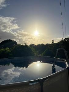 a swimming pool with the sun reflecting on the water at La Jéméli in Grand-Bourg
