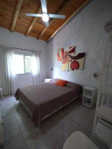a bedroom with a bed and a painting on the wall at Cabañas Paraje Noviembre in Nono