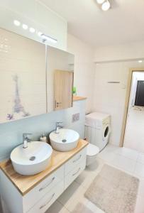 ein Badezimmer mit zwei Waschbecken und einer Toilette in der Unterkunft Exclusive Apartment SIBIU in Sibiu
