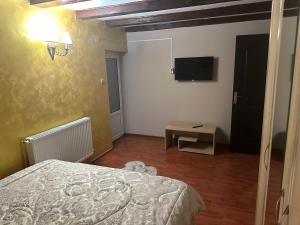 a bedroom with a bed and a flat screen tv at Casa Bonita in Buşteni