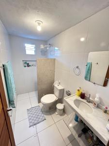 ein weißes Badezimmer mit Toilette und Waschbecken in der Unterkunft Casa Preá in Cruz