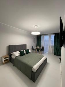a bedroom with a bed and a table in it at Luxury Apartments Kamienna Góra in Kamienna Góra