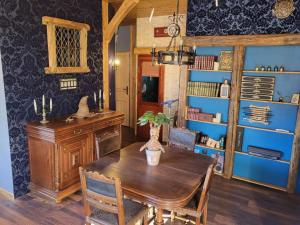 a dining room with a wooden table and a blue wall at L'Entre 2 Cols in Saint-Martin-sur-le-Chambre