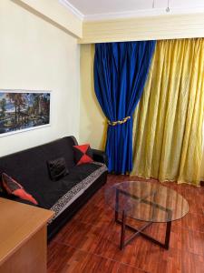 a living room with a black couch and a glass table at Modern Comfort Minutes from Plaka & Monastiraki in Athens