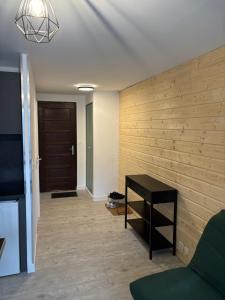 a living room with a wooden accent wall and a table at Studio Tezoto in Briançon
