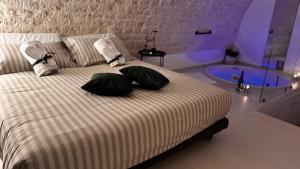 ein Schlafzimmer mit einem Bett mit zwei Kissen und einer Badewanne in der Unterkunft Suite Bimbà in Noci