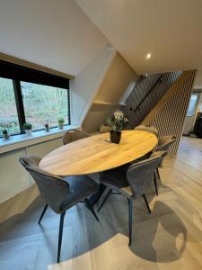 a dining room with a wooden table and chairs at Forest Lodge Durbuy in Durbuy