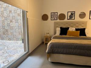 a bedroom with a bed and a large window at Studio Palermo Hollywood location! in Buenos Aires