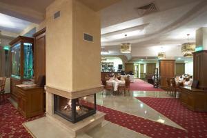 a lobby with a fireplace in the middle of a restaurant at Pinewood ANG premium luxurious apartment 15 in Borovets