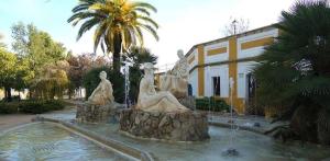 a statue in front of a building with a fountain at Casa Due Amori in Montilla