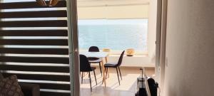 a dining room with a table and a view of the ocean at Depto Amoblado en Reñaca Frente al Mar in Viña del Mar
