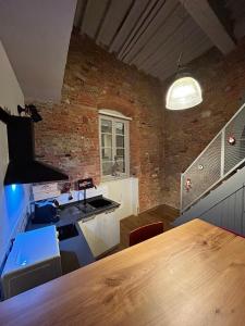 a kitchen with a wooden table and a brick wall at La stanza dei citti-Lapo in Arezzo