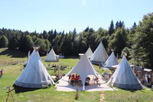 een stel blauw-witte tenten in een veld bij Village Tipi in La Féclaz