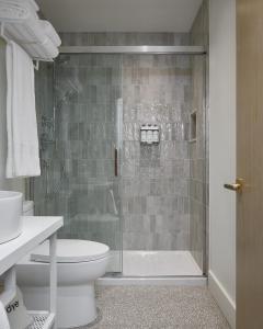 a bathroom with a shower with a toilet and a sink at The Beach Motel in Southampton +28 photos