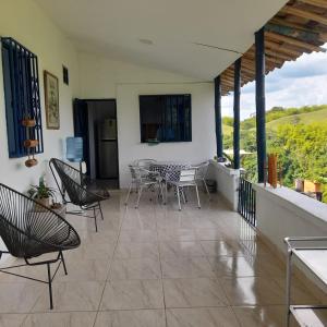 a patio with chairs and a table on a balcony at Casa Alto Bonito in Quimbaya