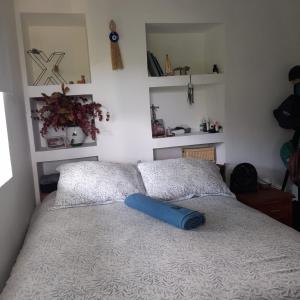 a bed with a blue pillow on top of it at Casa Alto Bonito in Quimbaya