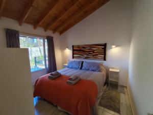 Un dormitorio con una cama con dos toallas encima. en Apart HAKUNA PEHUENIA, en Villa Pehuenia