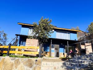 una mujer sentada frente a una casa en Apart HAKUNA PEHUENIA, en Villa Pehuenia