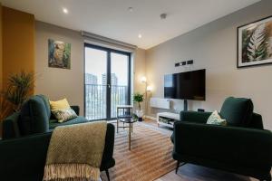 a living room with two green couches and a flat screen tv at Jungle Luxe Retreat, 2Bed 2Bath Leeds, Center & Stadium in Leeds