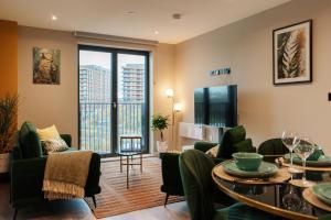 a living room with green furniture and a large window at Jungle Luxe Retreat, 2Bed 2Bath Leeds, Center & Stadium in Leeds