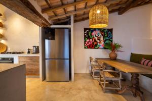a kitchen with a wooden table and a refrigerator at Casa CP, localização incrível em Trancoso, no Quadrado Historico in Porto Seguro +28 photos