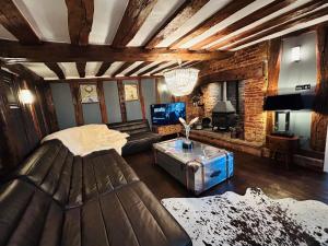 a living room with a couch and a table at The Foremans House, With Hot Tub, A luxurious Historical pre 16th Century Grade II Listed House, location Essex in a picturesque Village, Country Pub In walking Distance in Ridgewell