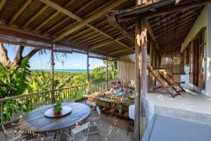 a patio with a table and chairs on a balcony at Casa CP, localização incrível em Trancoso, no Quadrado Historico in Porto Seguro