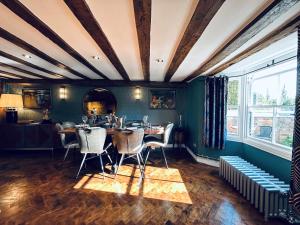 a dining room with green walls and a table and chairs at The Foremans House, With Hot Tub, A luxurious Historical pre 16th Century Grade II Listed House, location Essex in a picturesque Village, Country Pub In walking Distance in Ridgewell