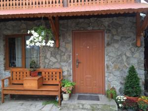 a house with a wooden door and a bench at Cottage Spadok in Vorokhta