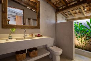 a bathroom with a sink and a toilet and a mirror at Casa CP, localização incrível em Trancoso, no Quadrado Historico in Porto Seguro