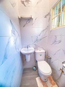 a bathroom with a toilet and a sink at Résidence Raffinée-Pour une expérience unique in Cotonou