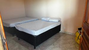 due letti singoli in una piccola stanza con tre tettine di tistrinittritistritistrite di Casa em Pirambu a Pirambu