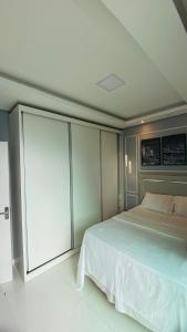 a bedroom with a large white bed and cabinets at Riverfront Retreat Prime Location Apartment with Stunning Views of the RioNegro in Manaus