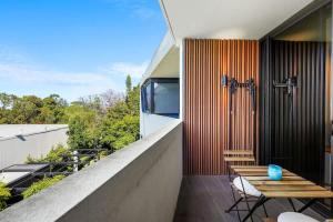 a balcony with a wooden bench and a wooden table at Perfectly Located Executive 1BR at Caulfield North in Melbourne