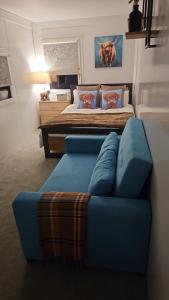 una camera con un divano blu e un letto di Moun Bolton Cabin 'Chester' a Portlaw