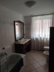 Un baño con bañera, lavabo e inodoro. en Casa Mo, en Alba