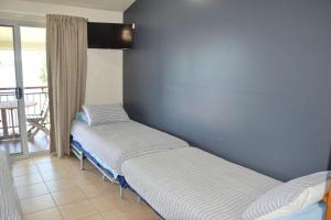 two beds in a room with a balcony at Coast and Country Cabin 2 in Pelican Island