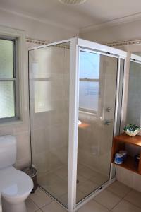 a shower stall in a bathroom with a toilet at Coast and Country Cabin 2 in Pelican Island