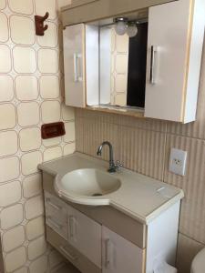 a bathroom with a sink and a mirror at Apartamento Iguaba Grande, bairro Canellas City , Condomínio Claudia, em frente ao Quiosque do popeye in Iguaba Grande