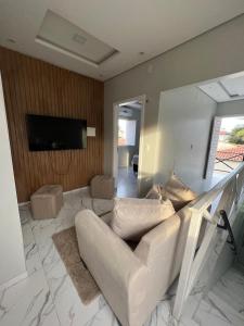 a living room with a white couch and a television at Apartamento Brisa Icaraizinho Villa brisa Icaraizinho in Amontada +14 photos