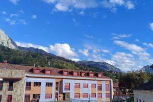 a large building with mountains in the background at Vistas Sobia San Martín de teverga in San Martín