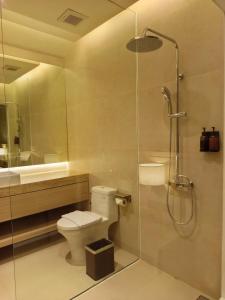 a bathroom with a shower and a toilet and a sink at Ow! Hotel Boutique Kemayoran in Jakarta +25 photos