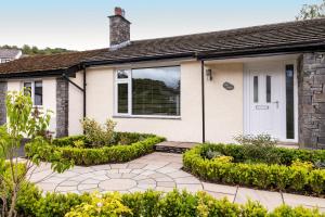 a house with a white door and a courtyard at Hillcrest - Central 2 Bed Flat with Parking in Bowness-on-Windermere